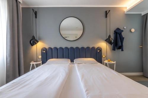 a large bed in a room with a mirror at Hotel Europa in Garda