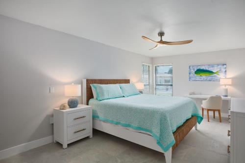 a white bedroom with a bed and a desk at Blind Pass C106 - Upgraded Ground Floor Residence at Blind Pass in Sanibel