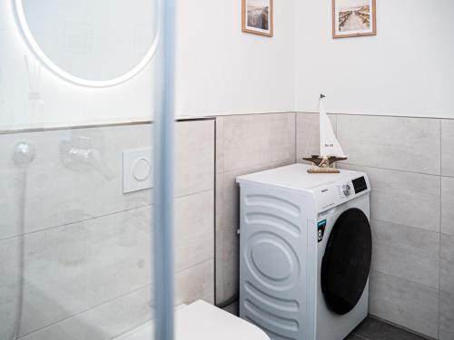 a washing machine in a bathroom with a mirror at Flussblick am Töpferberg 4 in Bad Schwartau