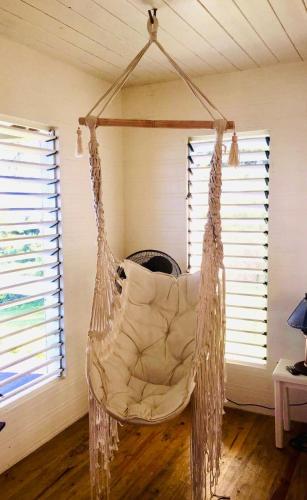 a hanging hammock in a room with two windows at Lomani in Matei
