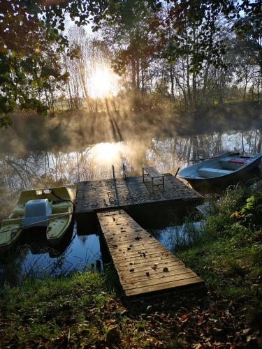 a dock with two boats on a lake at Kattugglans Guestroom 1 in Ljungby