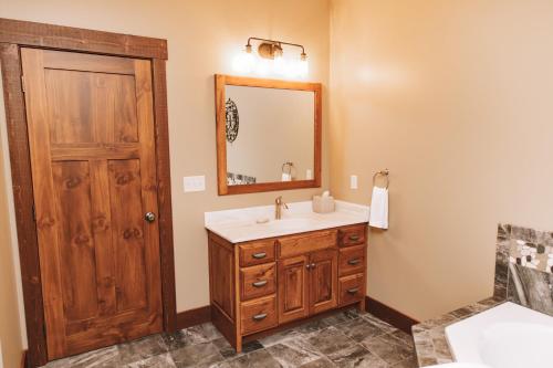 a bathroom with a sink and a mirror at Sojourner's Lodge & Log Cabin Suites in Dundee