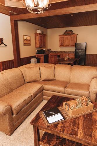 a living room with a brown couch and a table at Sojourner's Lodge & Log Cabin Suites in Dundee
