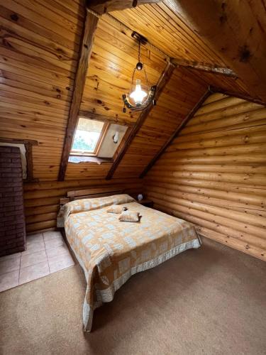 a bedroom with a bed in a wooden room at Sofiya in Mykulychyn