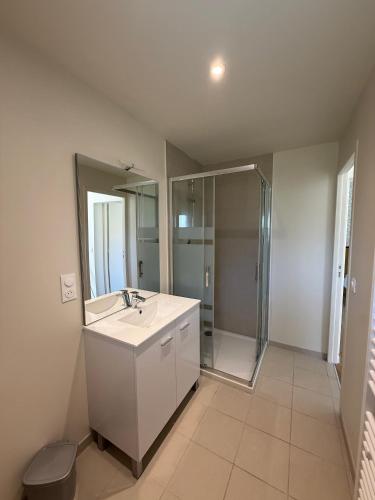 une salle de bain blanche avec un lavabo et une douche dans l'établissement Village Vacances de Bretou, à Eymet