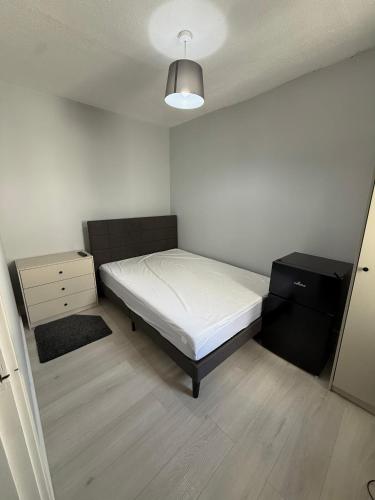 a small bedroom with a bed and a dresser at Modern bedroom near town centre in Bridgwater