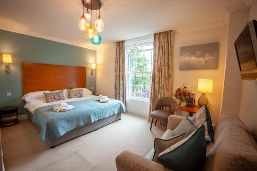 ラドローにあるFishmore Hall Hotel and Boutique Spaのベッドとソファのある寝室