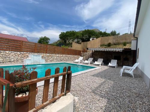 a swimming pool in a yard with a wooden fence at House on the hill in Mostar
