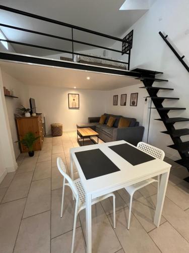 un salon avec une table et des chaises blanches dans l'établissement Appartement confortable et cosy, à Montélimar