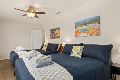 a living room with a blue couch and a ceiling fan at Rivertop Hideaway with HUGE views-Hot Tub-EV-more! in Ahwahnee
