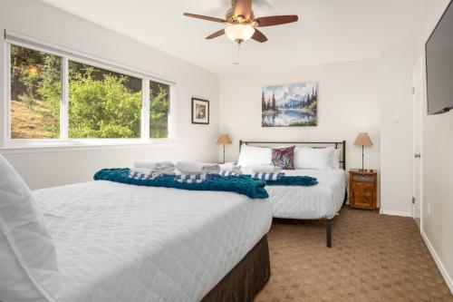 a bedroom with two beds and a ceiling fan at Rivertop Hideaway with HUGE views-Hot Tub-EV-more! in Ahwahnee