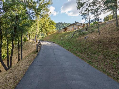 an empty road in the middle of a field at Rivertop Hideaway with HUGE views-Hot Tub-EV-more! in Ahwahnee