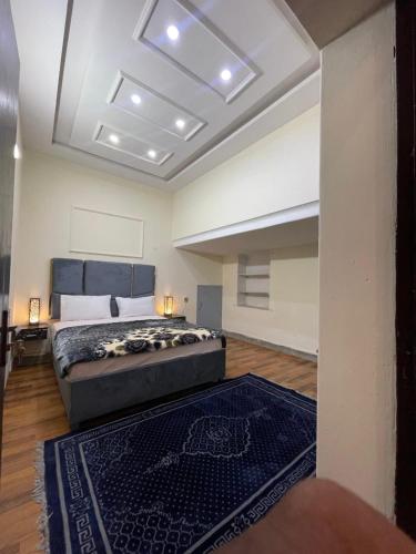 a large bedroom with a bed and a rug at Hotel The Shalimar in Lahore