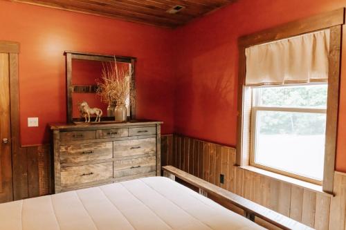 a bedroom with a bed and a mirror and a window at Sojourner's Lodge & Log Cabin Suites in Dundee
