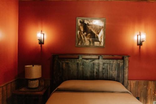 a bedroom with a bed and a picture of a horse on the wall at Sojourner's Lodge & Log Cabin Suites in Dundee