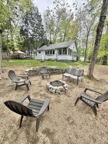 a group of benches sitting around a fire pit at KENDALL COTTAGE LIMIT 6 villa in North Sebago