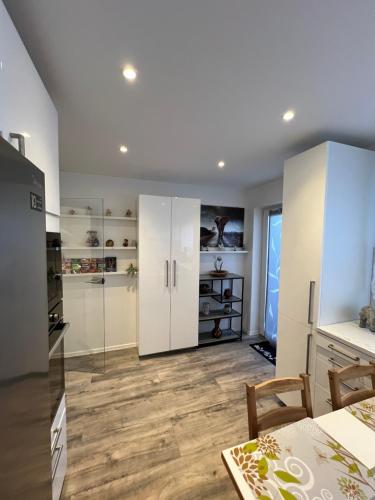 a kitchen with white cabinets and a wooden floor at VipStay - Stilvoll und geräumige Apartments mit Terasse oder Balkon, Küche, kostenloses Parken, WLAN, Smart Tv in Wiesloch
