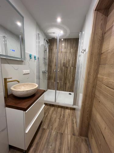 a bathroom with a sink and a shower at VipStay - Stilvoll und geräumige Apartments mit Terasse oder Balkon, Küche, kostenloses Parken, WLAN, Smart Tv in Wiesloch