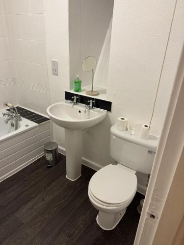 a white bathroom with a toilet and a sink at Superking bedroom near James cook hospital in Middlesbrough