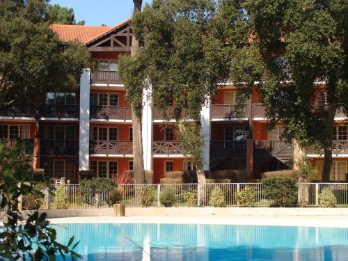 un immeuble avec une piscine devant un immeuble dans l'établissement Maryse, à Moliets-et-Maa