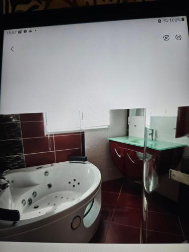 a bathroom with a tub and a sink at Maison familiale in Plouzané