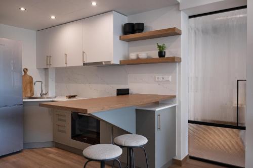 a kitchen with a counter and stools in it at Olivia Flat 1 in Kalamata