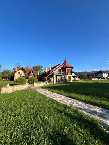 a house with a walkway in front of a yard at Sofiya in Mykulychyn