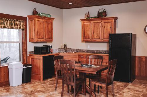 a kitchen with a table and a black refrigerator at Sojourner's Lodge & Log Cabin Suites in Dundee