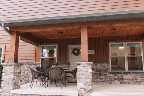 a covered patio with a table and chairs at Sojourner's Lodge & Log Cabin Suites in Dundee