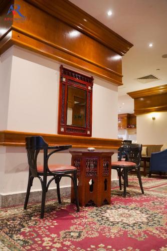 a room with a table and chairs and a mirror at AIFU Hotel El Montazah Alexandria in Alexandria
