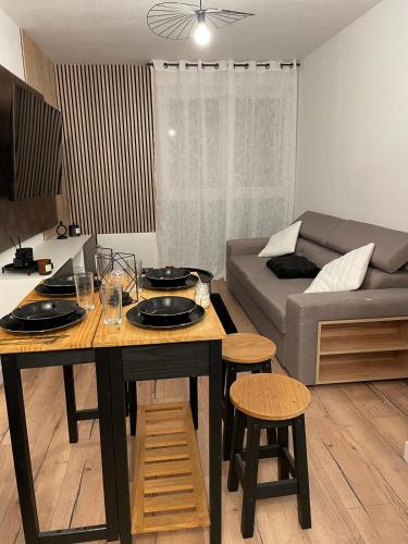 un salon avec une table et un canapé dans l'établissement T2 design centre Aucamville - Clim-Parking, à Aucamville