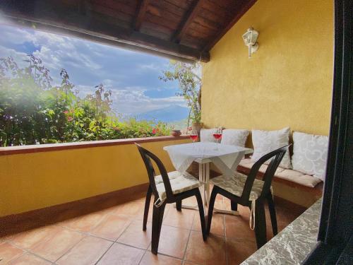 una mesa blanca y sillas en un balcón con ventana en BellaVista Apartments, en Taormina