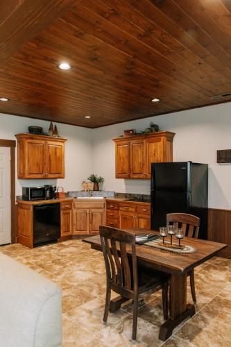 a kitchen with wooden cabinets and a wooden table at Sojourner's Lodge & Log Cabin Suites in Dundee