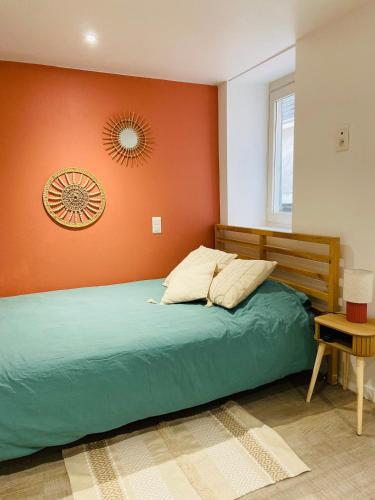 a bedroom with a bed with an orange wall at Terracotta, Appartement, Centre historique in Auch