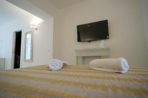 a bedroom with a bed with a tv on the wall at Praialonga Suites with Pool and Garden in Le Castella