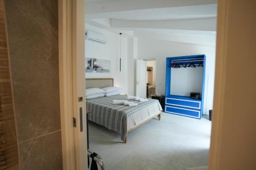 a bedroom with a bed and a blue mirror at Praialonga Suites with Pool and Garden in Le Castella