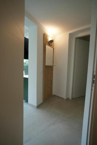 an empty room with a door and a hallway at Praialonga Suites with Pool and Garden in Le Castella