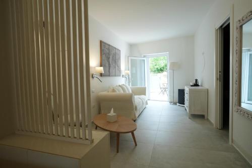 a living room with a couch and a table at Praialonga Suites with Pool and Garden in Le Castella