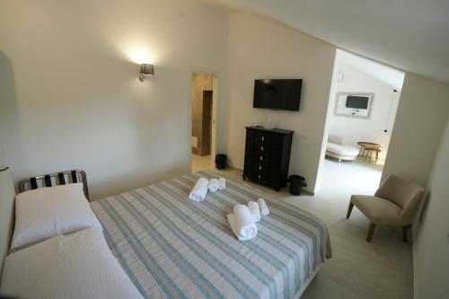 a bedroom with a bed with white towels on it at Praialonga Suites with Pool and Garden in Le Castella
