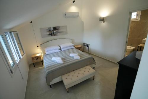 a bedroom with a bed with two white towels at Praialonga Suites with Pool and Garden in Le Castella