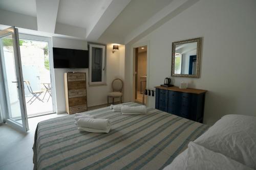 a bedroom with a large bed with two towels on it at Praialonga Suites with Pool and Garden in Le Castella