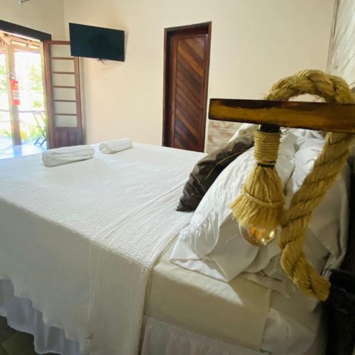 a white bed with a rope attached to it at Encanto Paraty Beach in Paraty