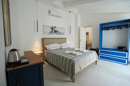 a bedroom with a bed and a desk and a television at Praialonga Suites with Pool and Garden in Le Castella