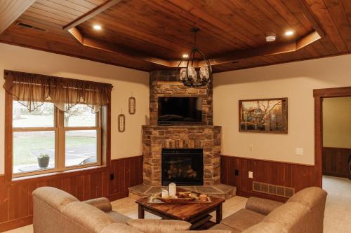a living room with a fireplace and a tv at Sojourner's Lodge & Log Cabin Suites in Dundee