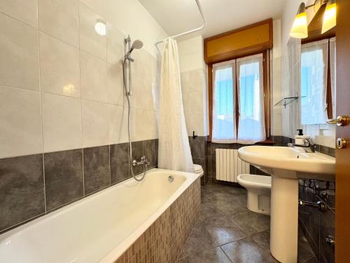 a bathroom with a tub and a sink and a toilet at Spacious 2-Bedroom Apartment with Large Terrace in Milan