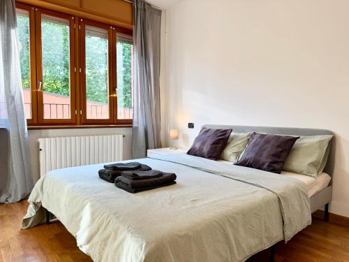 a bedroom with a white bed with a large window at Spacious 2-Bedroom Apartment with Large Terrace in Milan