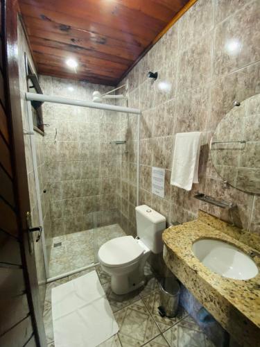 a bathroom with a toilet and a shower and a sink at Encanto Paraty Beach in Paraty