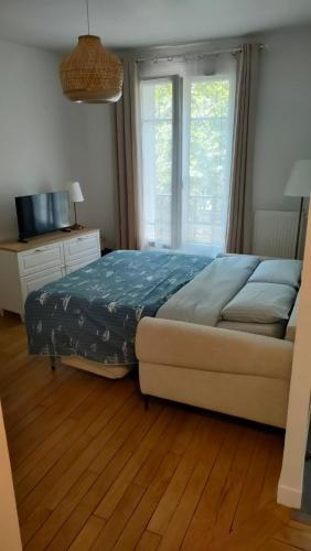 une chambre avec un lit et une grande fenêtre dans l'établissement Boul'Bohème - 4 guests 1 bedroom 2 beds 1 bathroom, à Boulogne-Billancourt