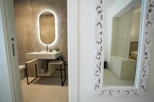 a bathroom with a sink and a mirror at Praialonga Suites with Pool and Garden in Le Castella