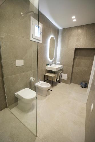 a bathroom with a toilet and a sink at Praialonga Suites with Pool and Garden in Le Castella